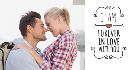 Hip young couple smiling at each other against valentines messageの写真素材