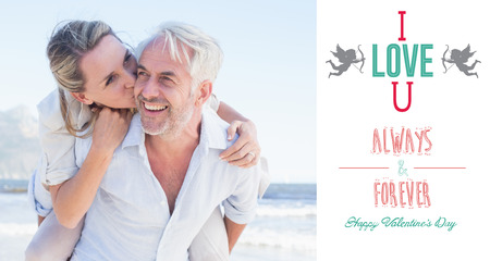 Man giving his smiling wife a piggy back at the beach against i love you messageの写真素材