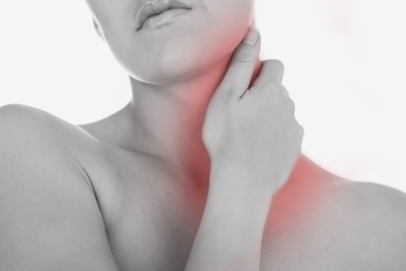 Woman massaging neck against white backgroundの写真素材