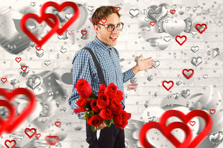 Geeky hipster holding a bunch of roses against grey valentines heart patternの写真素材