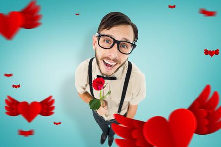 Geeky lovesick hipster holding rose  against blue vignette backgroundの写真素材