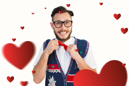 Geeky hipster wearing christmas vest against heartsの写真素材