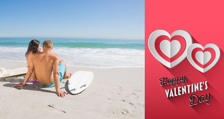 Pretty young couple with their surfboards looking at the sea against happy valentines dayの写真素材