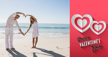 Cute couple forming heart shape with arms against happy valentines dayの写真素材