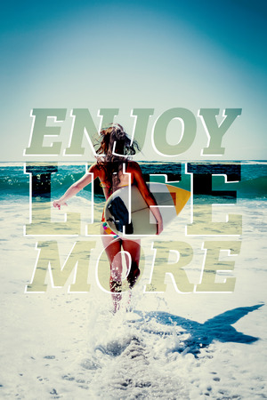 Fit surfer girl running to the sea with her surfboard against enjoy life more