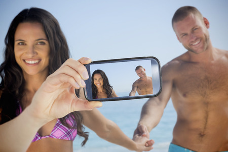 Composite of Couple taking selfie on smartphoneの写真素材