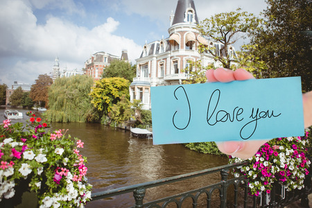 Hand showing card against canal in amsterdamの写真素材