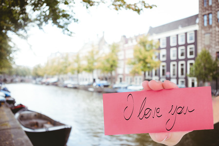 Hand showing card against canal in amsterdamの写真素材