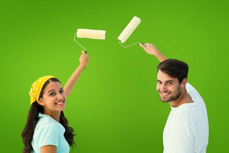 Happy young couple painting together against green vignetteの写真素材