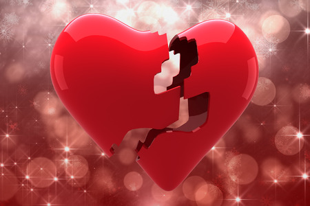 Broken heart against shimmering light design on redの写真素材