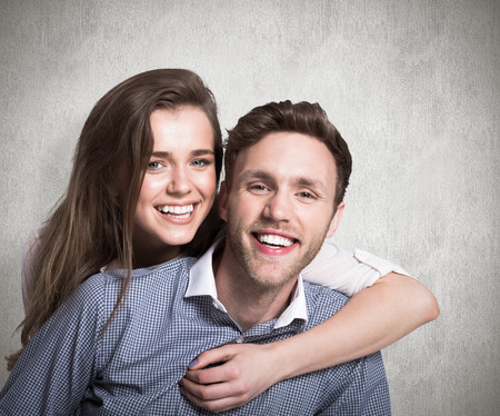 Close up of happy young couple against weathered surfaceの写真素材