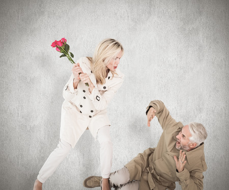 Angry woman attacking partner with rose bouquet against white backgroundの写真素材