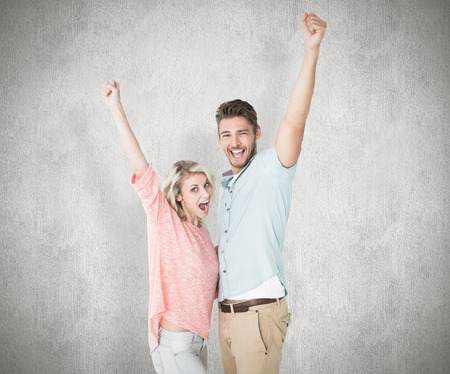 Attractive couple smiling and cheering against white backgroundの写真素材