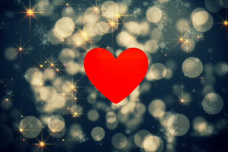 heart against shimmering light design on blackの写真素材