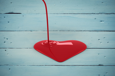 Liquid heart pouring against painted blue wooden planksの写真素材