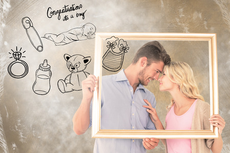Attractive young couple holding picture frame against congratulations its a boy
