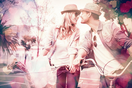 Hip young couple on a bike ride on a sunny day in the cityの写真素材