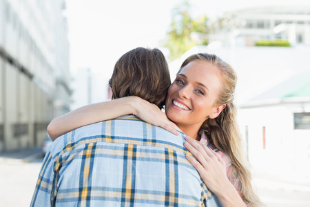 Attractive couple standing and hugging on a sunny day in the cityの写真素材