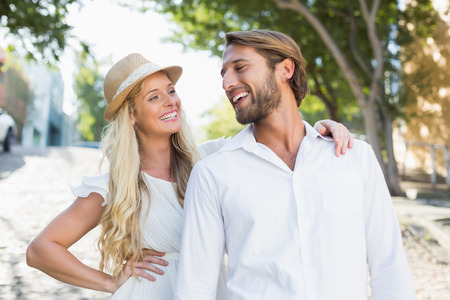 Attractive couple smiling at each other on a sunny day in the cityの写真素材