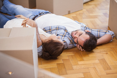 Cute couple lying on the floor in their new home