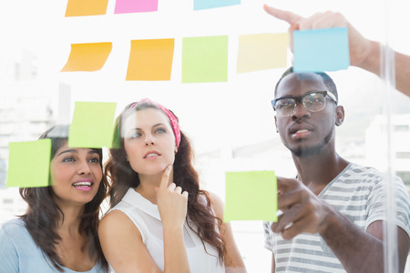 Focused teamwork reading sticky notes in the office