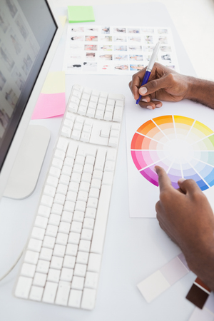 Businessman working with colour wheel and taking notes in the officeの写真素材