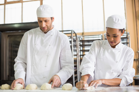 Team of bakers preparing dough in the kitchen of the bakery