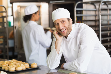 Baker smiling at the camera in the kitchen of the bakery