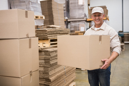 Portrait of worker carrying box in the warehouse