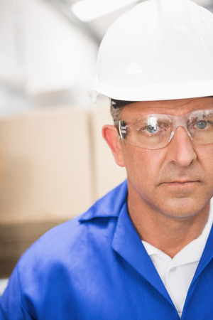 Close up portrait of worker wearing hard hat in the warehouseの写真素材