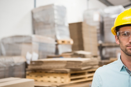 Close up portrait of worker wearing hard hat in the warehouseの写真素材