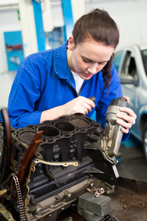 Mechanic working on an engine at the repair garageの写真素材