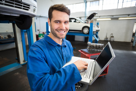 Mechanic using a laptop to work at the repair garage