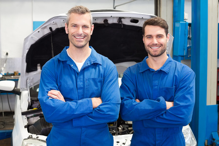 Team of mechanics smiling at camera at the repair garageの写真素材