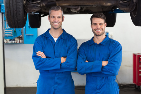 Team of mechanics smiling at camera at the repair garageの写真素材