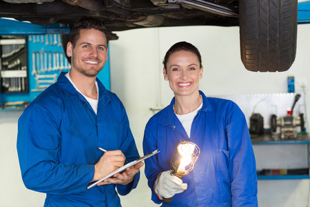 Team of mechanics smiling at camera at the repair garage