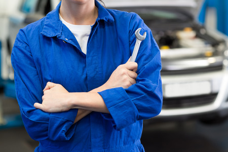 Mechanic holding wrench with crossed arms at the repair garageの写真素材