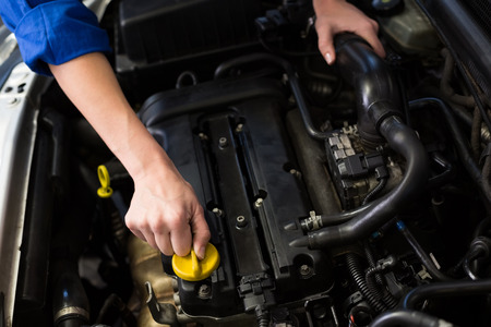Mechanic working under the hood at the repair garage