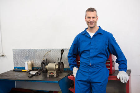 Smiling mechanic looking at camera at the repair garageの写真素材