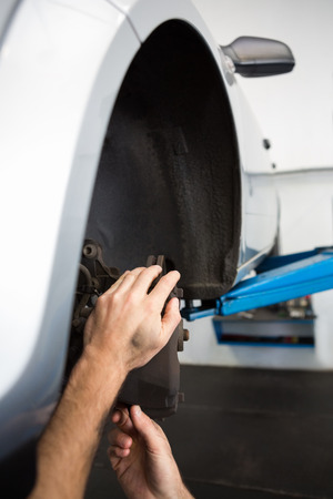 Focused mechanic adjusting the wheel at the repair garageの写真素材
