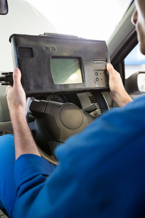 Mechanic using diagnostic tool in the car at the repair garageの写真素材