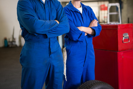 Team of mechanics standing with arms crossed at the repair garageの写真素材