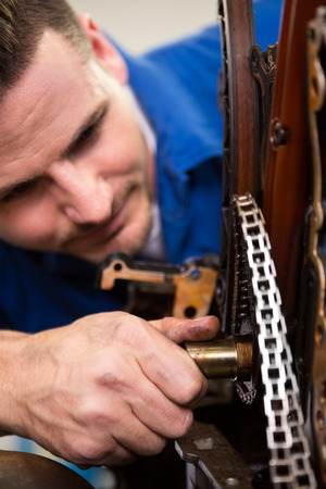 Mechanic working on an engine at the repair garageの写真素材