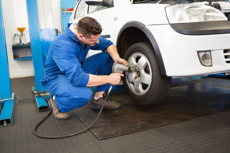Mechanic adjusting the tire wheel at the repair garageの写真素材
