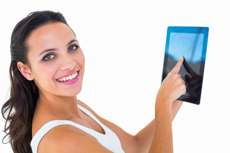 Pretty brunette using tablet pc on white backgroundの写真素材