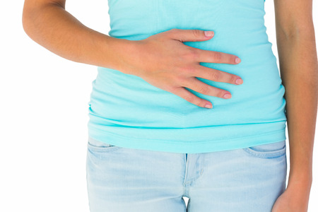 Slim woman with hand on stomach on white background