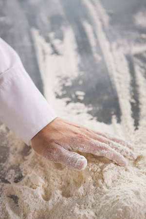 Close up of baker preparing dough in the kitchen of the bakeryの写真素材