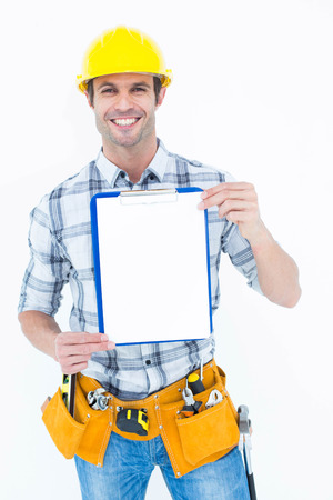 Portrait of confident carpenter holding clip board over white backgroundの写真素材