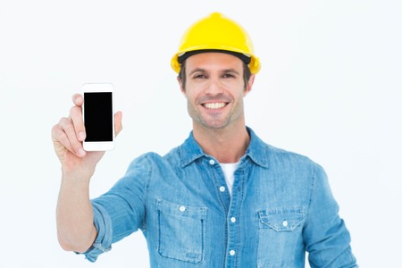 Portrait of happy carpenter showing smart phone over white backgroundの写真素材