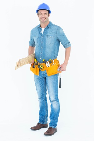 Portrait of happy carpenter with wooden planks over white backgroundの写真素材